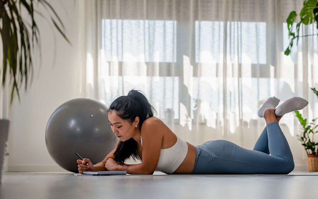 Young Asian yoga woman writing in her notebook