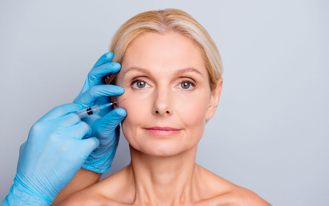 Portrait of calm serious charming aged woman with wrinkle getting injection in cheek