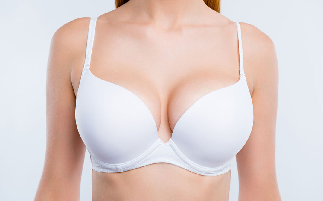 Cropped close-up portrait of nice attractive adorable girl chest after uplift injection wearing white bra