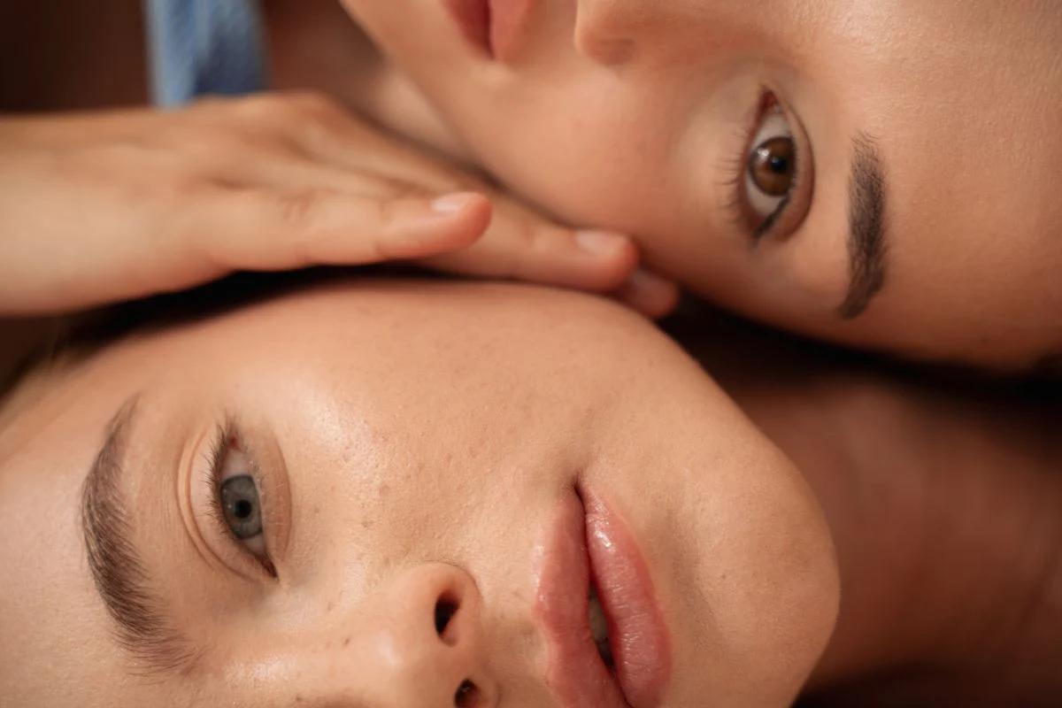 two beautiful woman with their heads on one another