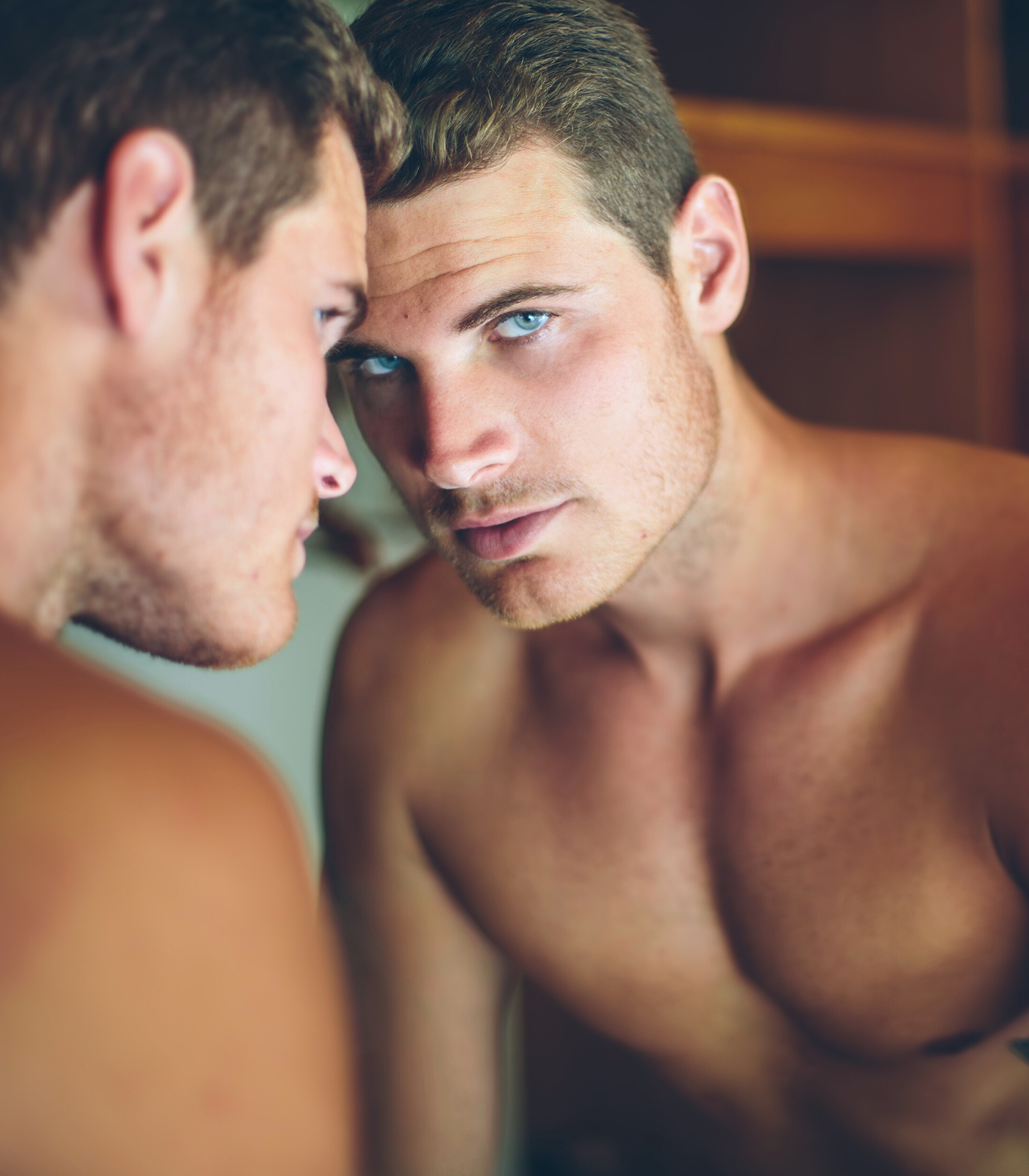 handsome young man looking in mirror handsome young man looking in mirror